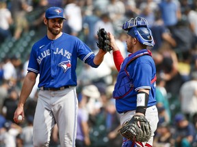 Toronto Blue Jays relief pitcher Jordan Romano (left) high-fives catcher Alejandro Kirk following a victory against the Seattle Mariners.