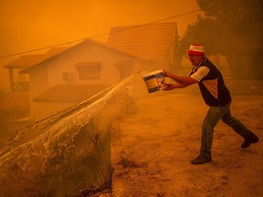 A local resident drops water as he fights the wildfire in the village of Gouves on Evia (Euboea) island, second largest Greek island, on Aug. 8, 2021.