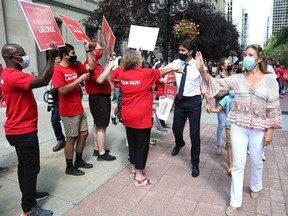 Canada's Prime Minister Justin Trudeau and his wife Sophie Gregoire Trudeau greets supporters during a walk to his campaign bus on August 15, 2021 in Ottawa.