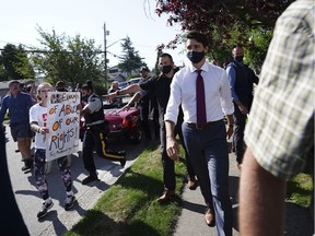 A protester yells at Liberal Leader Justin Trudeau as he makes his way to a motorcade in Surrey, B.C., on Wednesday, Aug. 25, 2021.