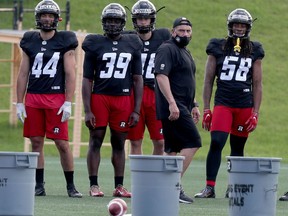 A file photo from July shows defensive co-ordinator Mike Benevides, second from right, with Redblacks players.