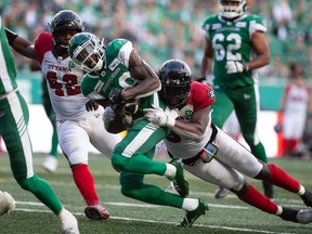Redblacks defensive lineman Kene Onyeka (99) pulls down Saskatchewan Roughriders wide receiver Paul McRoberts Jr. (88) during a CFL football game at Mosaic Stadium in Regina, Saskatchewan on August 21, 2021.