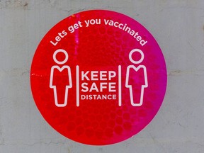 Files: A social distancing sign at a mass vaccination site.