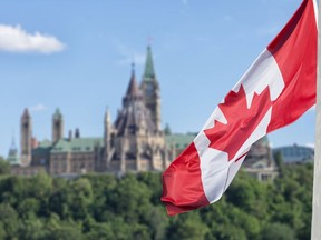 FILE: The Canadian flag waving with Parliament Buildings hill and Library in the background.