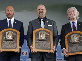 From left: Derek Jeter, Larry Walker and Ted Simmons hold their plaques after being enshrined in the Baseball Hall of Fame in Cooperstown, N.Y., on Wednesday.