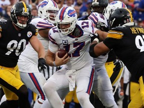 Bills QB Josh Allen is caught in the clutches of Steelers’ Cameron Heyward (right) as T.J. Watt closes in yesterday.  Getty Images