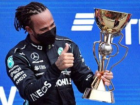 Winner Mercedes' British driver Lewis Hamilton celebrates on the podium after the Formula One Russian Grand Prix at the Sochi Autodrom circuit in Sochi on September 26, 2021.
