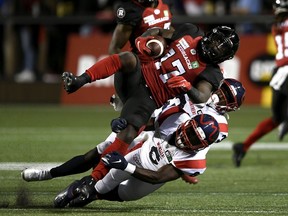 Redblacks wide receiver DeVonte Dedmon (17) is tackled by Alouettes defensive backs Adarius Pickett (6) and Rodney Randle Jr. (32) during first-half action on Friday night.