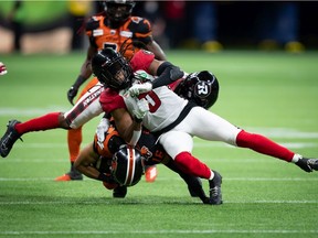 Ottawa Redblacks' Don Unamba, front right, B.C. Lions' Bryan Burnham, left, and Ottawa's Randall Evans, back, collide after Burnham made a reception during the second half of a CFL football game in Vancouver, on Saturday, September 11, 2021.