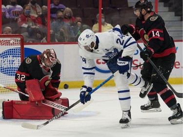 Ottawa Senators goalie Filip Gustavsson (32) makes a save in front of Toronto Maple Leafs  right wing Wayne Simmonds (24) in the first period at the Canadian Tire Centre.