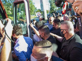 Rocks strike  Prime Minister Justin Trudeau in the back and head as he boards his bus at the end of a campaign stop at the  London Co-Operative Brewing Company in London, Ont. on Monday Sept. 6, 2021.