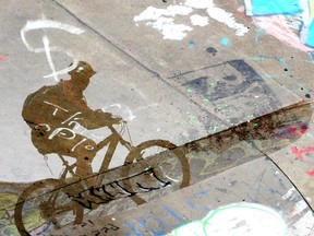 FILE: A cyclist reflect in a puddle.