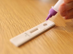 In this photo illustration, a man uses a COVID-19 rapid antigen test kit at home on Sept. 29, 2021 in Sydney, Australia.