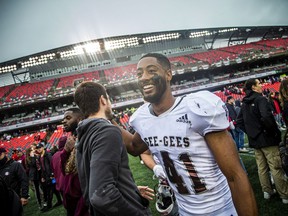 The Gee-Gees' Chris Ciguineau (41) celebrates the win as fans ran onto the field after Saturday's 19-17 win over the Ravens.