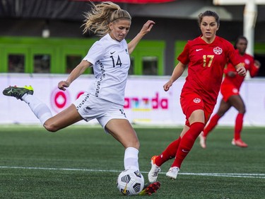 New Zealand's Katie Bowen (14) kicks the ball away from Canada's Jessie Fleming.
