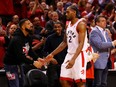 Kawhi Leonard of the Toronto Raptors high fives rapper Drake during game four of the NBA Eastern Conference Finals between the Milwaukee Bucks and the Toronto Raptors on May 21, 2019.