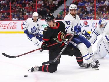 Shane Pinto of the Ottawa Senators battles for the puck with TJ Brodie of the Toronto Maple Leafs.