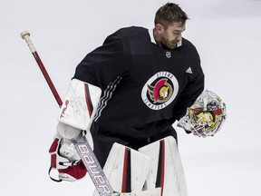 Ottawa Senators goaltender Matt Murray heads to the bench to have his mask repaired during team practice at the Canadian Tire Centre, Oct. 13, 2021.