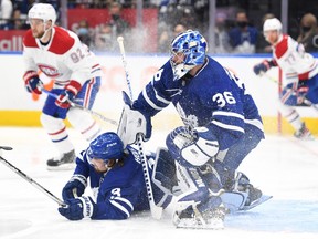 Maple Leafs' Justin Holl falls to the ice in front of goalie Jack Campbell in the first period against Montreal Canadiens at Scotiabank Arena on Wednesday, Oct. 13, 2021.