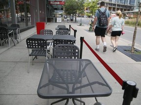 Empty tables outside of a downtown Toronto restaurant on Sunday July 18, 2021.