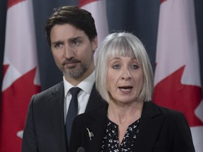 Prime Minister Justin Trudeau looks on as Minister of Health Patty Hajdu responds to a question during a news conference on the coronavirus situation, in Ottawa, March 11, 2020.
