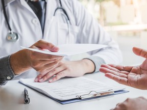 A doctor gives a medical form to a patient.