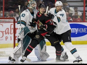 Senators center Josh Norris (centre) battles with San Jose Sharks center Tomas Hertl right) in front of goaltender James Reimer during the game on Thursday at Canadian Tire Centre. ERROL MCGIHON/POSTMEDIA NETWORK