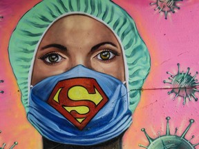 File photo/ A mural shows a health worker wearing a face mask with the Superman.