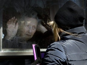 Diane Colangelo visits her 86-year-old mother Patricia through a window at Orchard Villa long-term care home in Pickering on April 22, 2020.