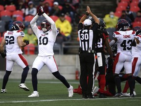 Alouettes defensive lineman Nick Usher (10) mimics the official as he signals a safety and two points against the Redblacks in the first half of Saturday's game.