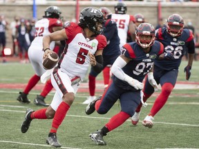 Ottawa Redblacks quarterback Caleb Evans runs with the ball during second half CFL football action against the Montreal Alouettes in Montreal on Monday, Oct. 11, 2021.