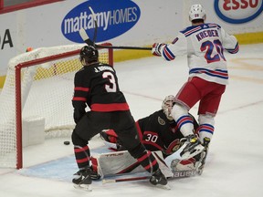 Senators goalie Matt Murray (30) takes a knee to the head from Rangers left-winger Chris Kreider (20) following Kreider's goal in the third period.