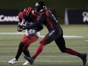 Ottawa Redblacks defensive back Randall Evans tackles Calgary Stampeders wide receiver Hergy Mayala as he runs with the ball last night at TD Place. The Canadian Press