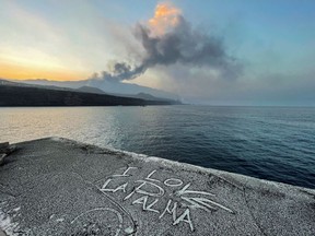 A handwritten message is seen on a rock covered with volcanic ash following the Cumbre Vieja volcano eruption, at the port of Tazacorte, on the Canary Island of La Palma, Spain October 2, 2021.