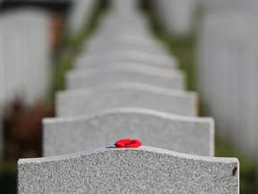 A poppy was left on a  tombstone of a soldiers in the National Military Cemetery after the Remembrance Day ceremonies at the National Military Cemetery at the Beechwood Cemetery in Ottawa, November 11, 2021.
