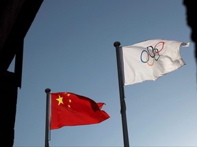 The Chinese and Olympic flags flutter at the headquarters of the Beijing Organizing Committee for the 2022 Olympic and Paralympic Winter Games in Beijing, China, Nov. 12, 2021.