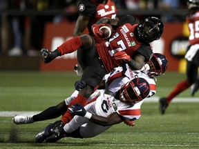 Ottawa Redblacks wide receiver DeVonte Dedmon (17) is tackled by Montreal Alouettes defensive back Adarius Pickett (6) and defensive back Rodney Randle Jr. (32) during first half CFL football action in Ottawa on Friday, Sept. 3, 2021.