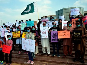 Members of VCare Welfare Trust hold placards during a protest against an alleged gang rape of a woman, in Karachi on September 13, 2020.