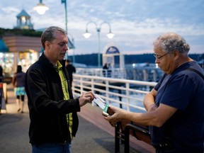 Green Party candidate Paul Manly speaks with local resident Colin Anstey about his concerns, as he campaigns in Nanaimo, B.C., Sept. 5, 2021.