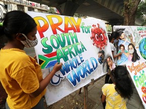 Students apply finishing touches to paintings made to create an awareness against the new coronavirus Omicron variant, in Mumbai, India, Monday, Nov. 29, 2021.