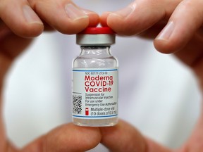 A pharmacist holds a vial of the Moderna vaccine.