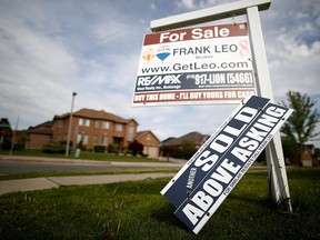 A real estate sign that reads "For Sale" and "Sold Above Asking" stands in front of housing in Vaughan, May 24, 2017.