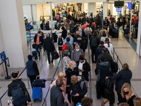 Passengers wait in line inside the terminal at Newark Liberty International Airport in Newark, New Jersey, Nov. 24, 2021.