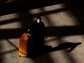 A woman arrives at Ben Gurion International Airport as Israel imposes new COVID-19 restrictions near Tel Aviv, Israel Nov. 28, 2021.