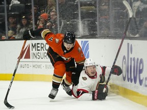Senators captain Brady Tkachuk, right, is checked to the ice by Ducks defenceman Cam Fowler during the first period of Friday's game in Anaheim.
