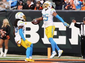 Chargers’ Chris Harris celebrates his interception with teammate Tevaughn Campbell against the Bengals in Cincinnati.