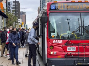 Passengers board OC Transpo R1 buses operating on Rideau Street adjacent to the Rideau LRT Station in this file photo.