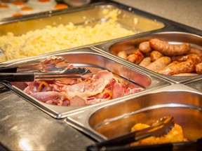 Hot counter containing warm breakfast items such as scrambled or fried eggs, bacon, sausages