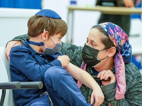 Eli Stern talks with his mom Hyla Stern after getting his shot at a Humber River Hospital vaccination clinic after Canada approved Pfizer's coronavirus disease (COVID-19) vaccine for children aged 5 to 11, in Toronto.