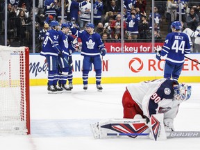 Maple Leafs' T.J. Brodie and teammates congratulate Auston Matthews as Blue Jackets goaltender Elvis Merzlikins kneels on the ice following Matthews’ goal during the second period in Toronto on Tuesday, Dec. 7, 2021.